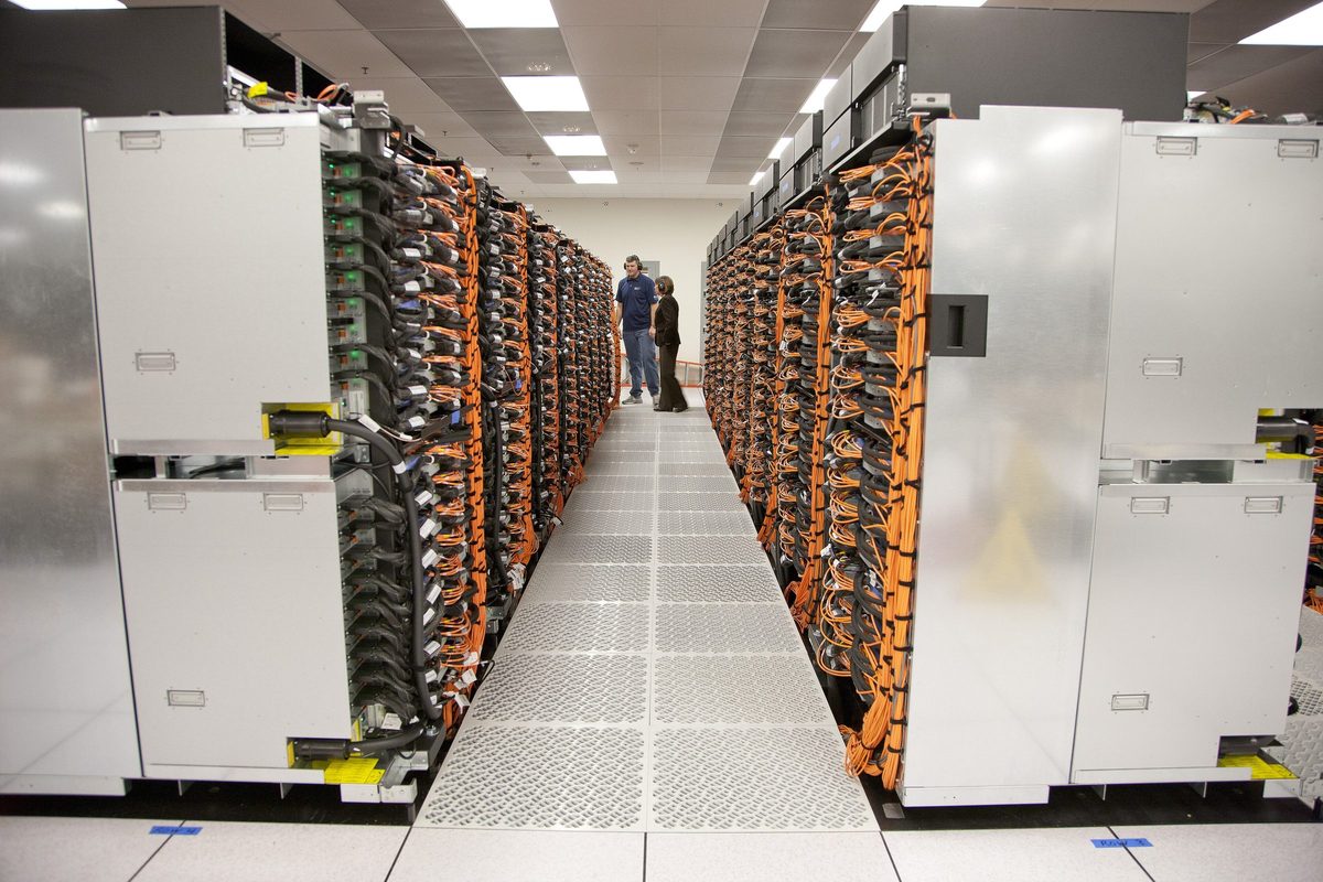 Pasillo de racks de una supercomputadora con cableado naranja